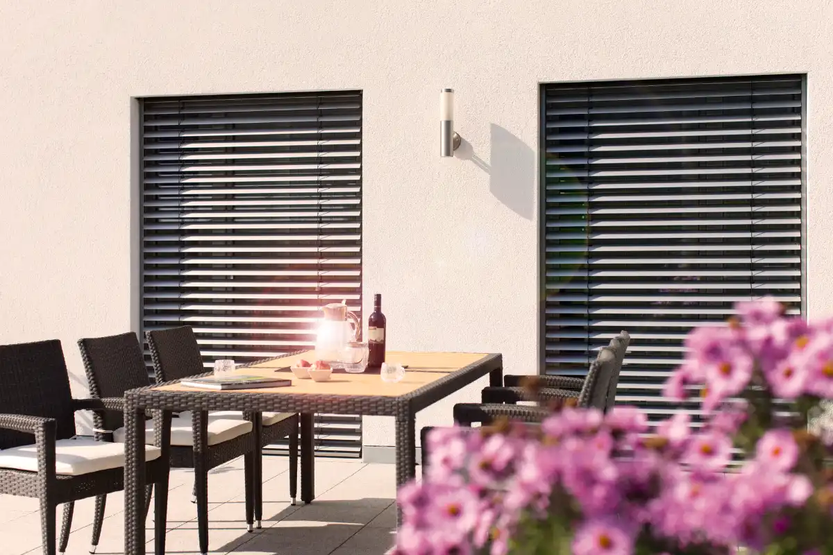 Moderne Terrasse mit Möbeln und dekorativen Blumen im Vordergrund