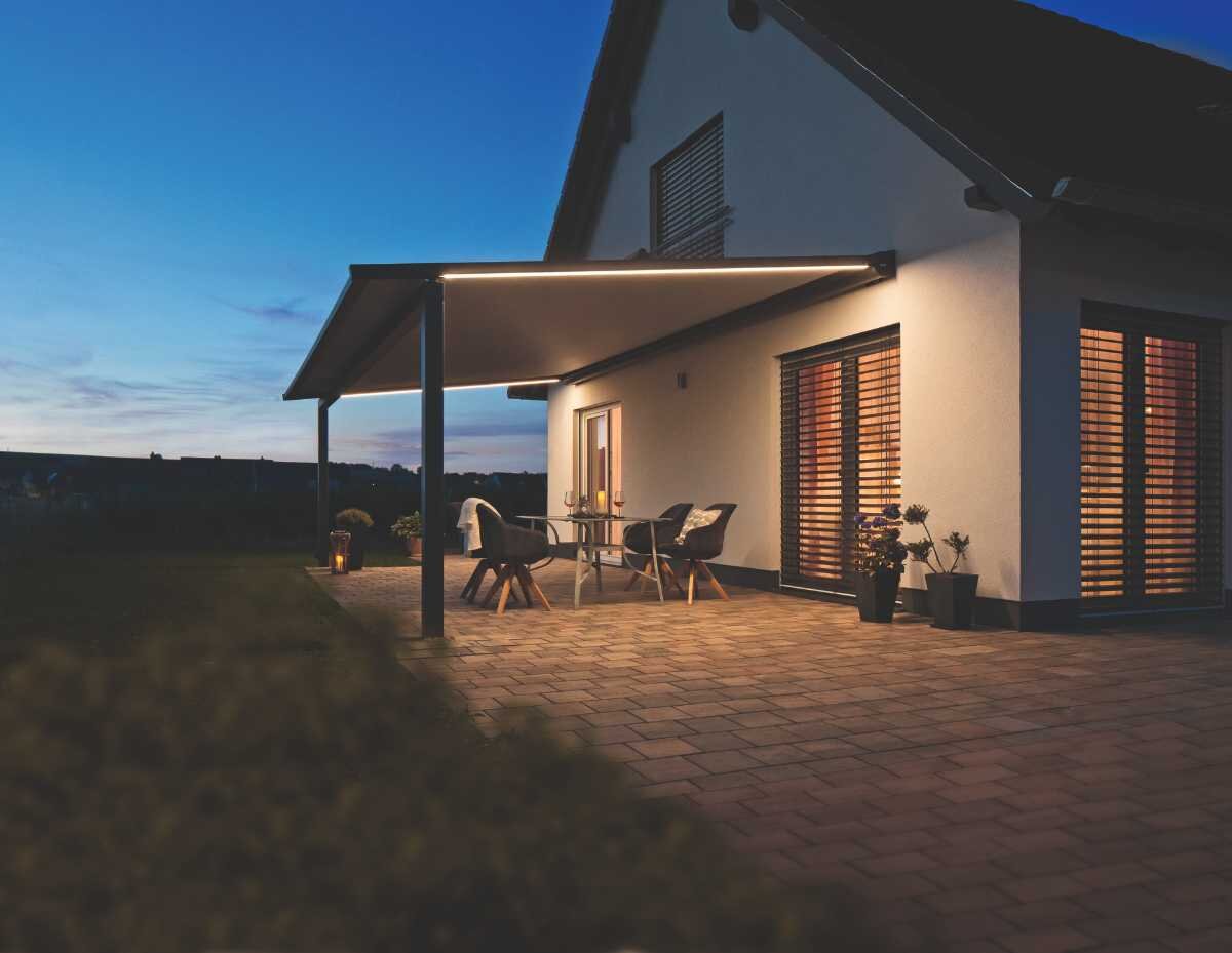 Moderne Terrasse bei Dämmerung mit Überdachung und stilvoller Beleuchtung